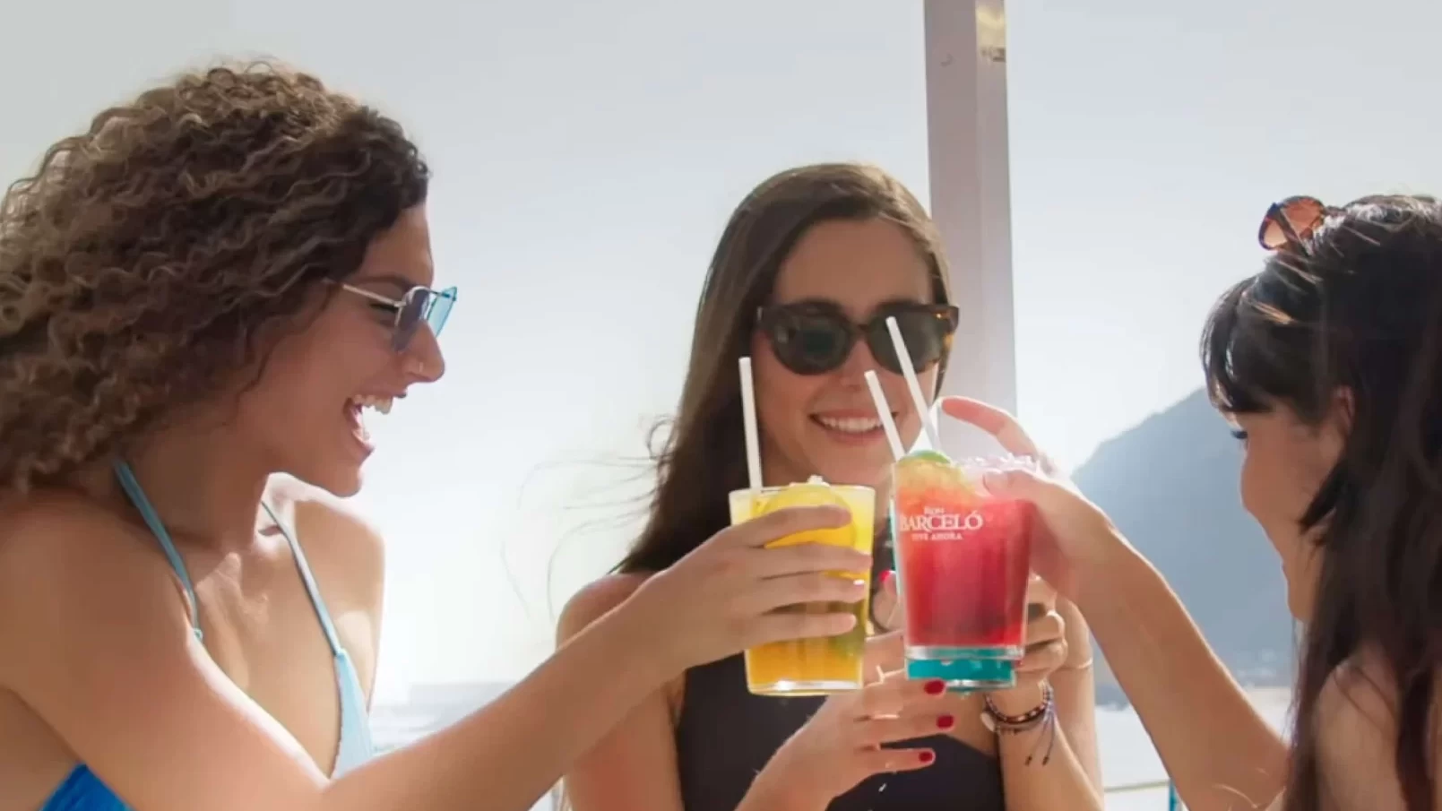 Tres chichas brindando en la playa.